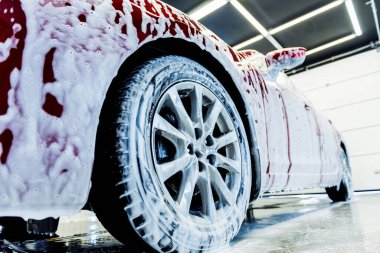 Araba yıkama servisinde aktif köpüklü kırmızı araba yıkama.