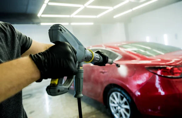 Arbeiter waschen Auto mit Hochdruckwasser in einer Waschanlage. — Stockfoto