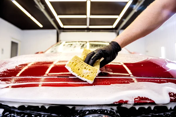 Pracovník mytí červené auto s houbou na mytí aut — Stock fotografie