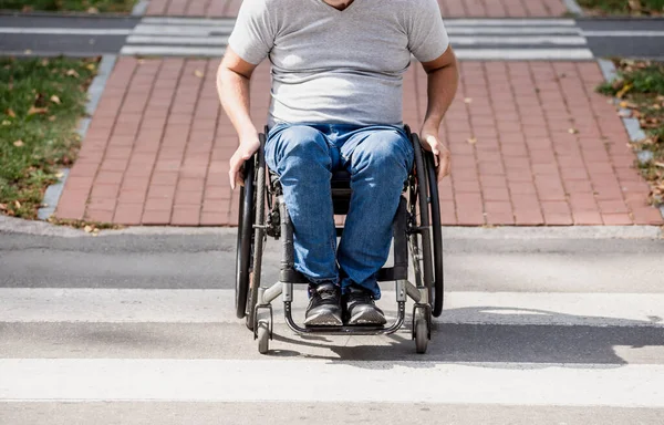 Bezbariérový muž na kolečkovém křesle křižovat ulici silnici — Stock fotografie