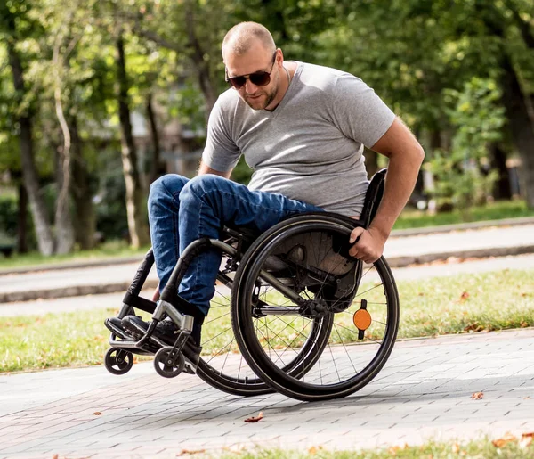Bezbariérový muž na invalidním vozíku procházka v parku uličky — Stock fotografie