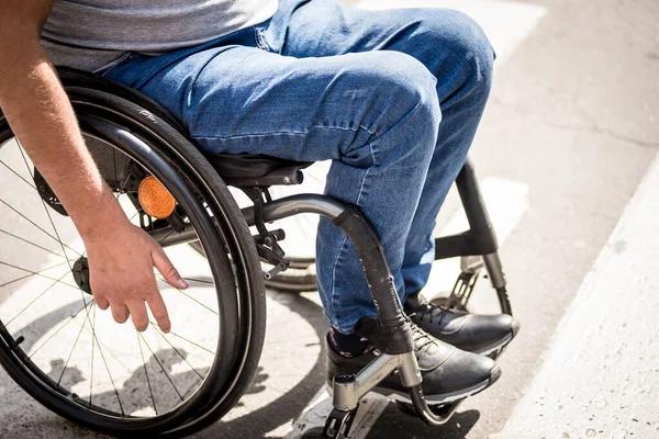 Mozgássérült férfi tolószékben sétál a park sikátorában. — Stock Fotó