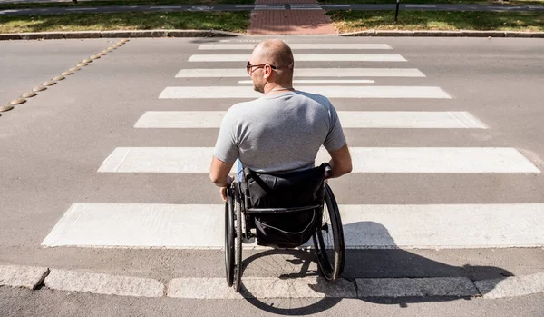 Hombre discapacitado en silla de ruedas cruzando calle carretera —  Fotos de Stock