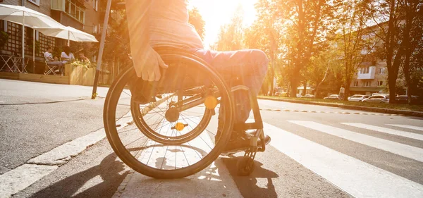 Hombre discapacitado en silla de ruedas cruzando calle carretera — Foto de Stock