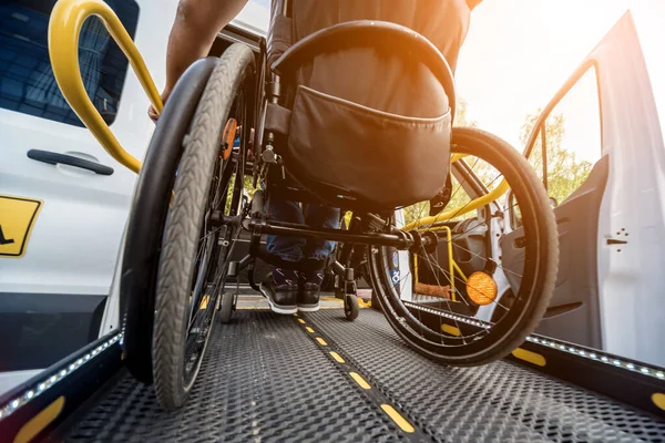 Un uomo sulla sedia a rotelle su un ascensore di un veicolo per disabili — Foto Stock