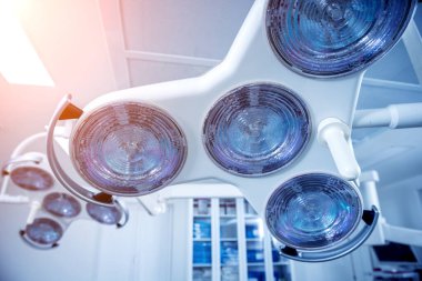 Hastanedeki ameliyat odasında büyük bir cerrahi lamba var..