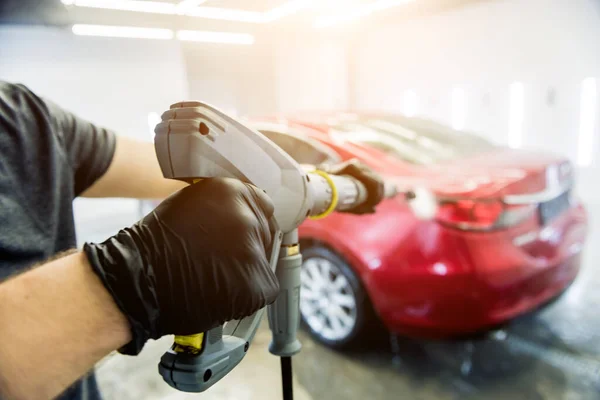 Arbeiter waschen Auto mit Hochdruckwasser in einer Waschanlage. — Stockfoto