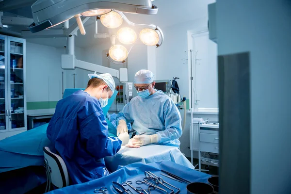 Хирурги в операционной пытаются спасти пациентам руку. — стоковое фото