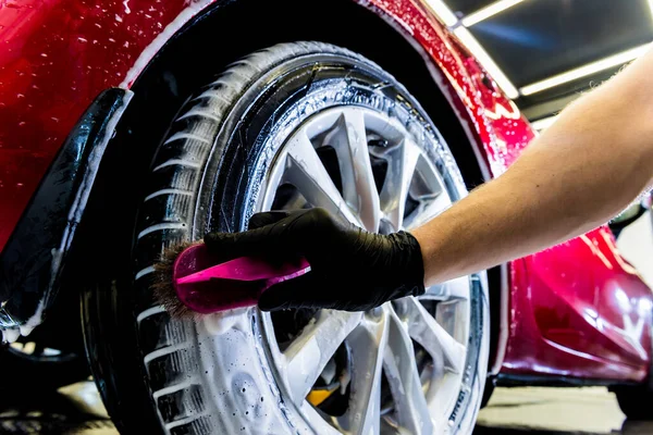 Rengöring av bilens hjul med pensel och vatten — Stockfoto