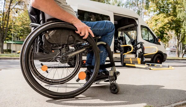 Tekerlekli sandalyedeki bir adam özel bir aracın asansörüne biner. — Stok fotoğraf