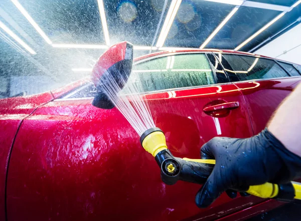 Servicemitarbeiter wäscht Auto in einer Waschanlage. — Stockfoto