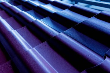 Mavi metalik çatı kiremitleri ve su damlaları.