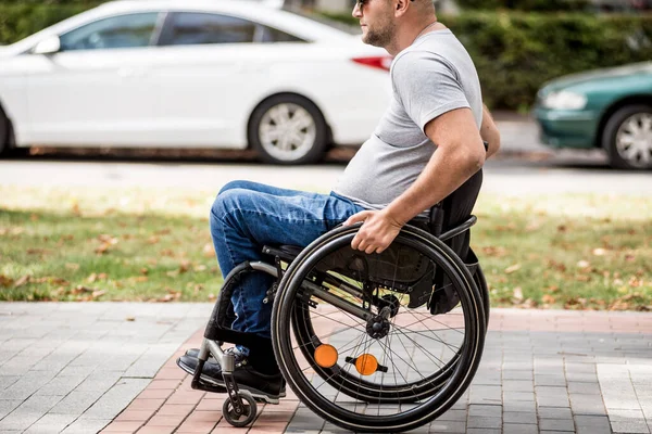 Gehandicapte man in rolstoel loopt in de steeg van het park — Stockfoto