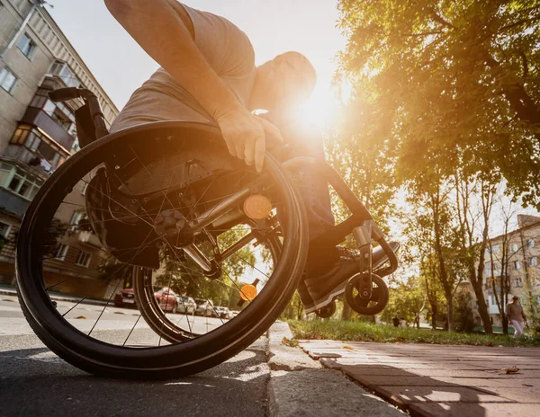 Handicapped man in wheelchair crossing street road