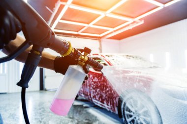 Araba yıkamada köpüklü araba yıkayan bir işçi..