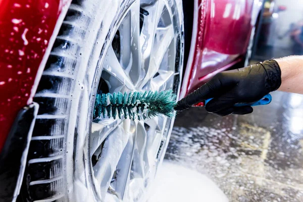 Nettoyage de la roue de voiture avec une brosse et de l'eau — Photo