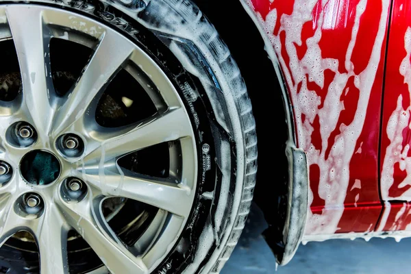 Lavado de coche rojo con espuma activa en el servicio de lavado de coches. — Foto de Stock