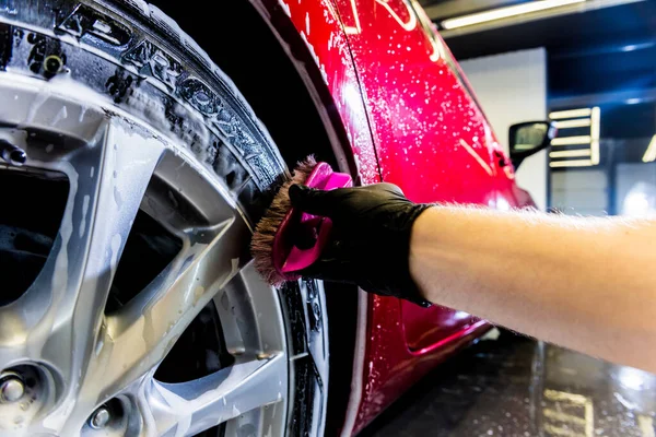 Rengöring av bilens hjul med pensel och vatten — Stockfoto
