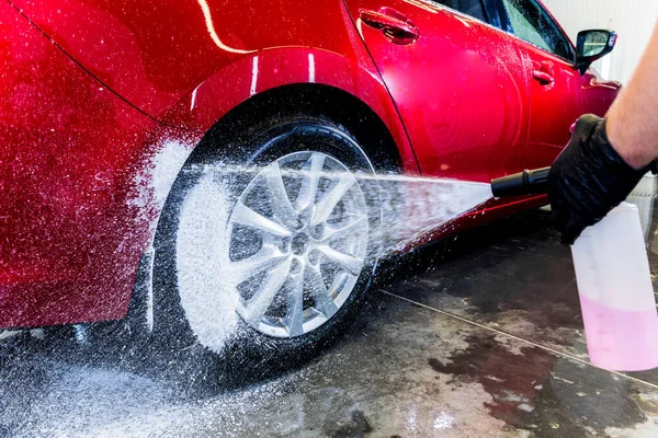 Limpieza de la rueda del coche con un cepillo y agua —  Fotos de Stock