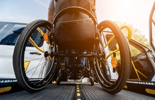 Un uomo sulla sedia a rotelle su un ascensore di un veicolo per disabili — Foto Stock