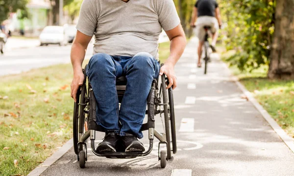 Gehandicapte man in rolstoel loopt in de steeg van het park — Stockfoto