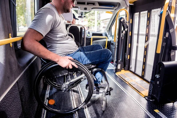 Un uomo su una sedia a rotelle all'interno di un veicolo specializzato — Foto Stock