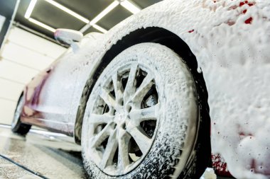 Araba yıkama servisinde aktif köpüklü kırmızı araba yıkama.