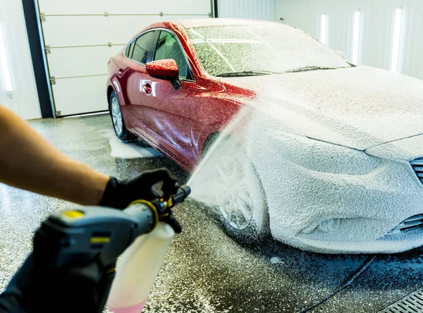 Trabajador de lavado de coches con espuma activa en un lavado de coches. — Foto de Stock