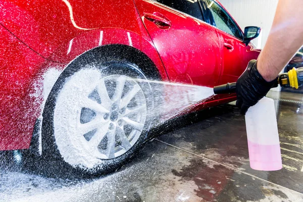 Limpieza de la rueda del coche con un cepillo y agua —  Fotos de Stock