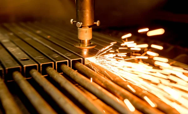A máquina de corte a laser cortando os furos nos tubos — Fotografia de Stock
