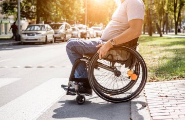 Handicapped man in wheelchair crossing street road clipart