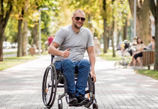 휠체어를 타고 공원 골목을 걷고 있는 장애인 — 스톡 사진