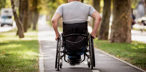 Handicapped man in wheelchair walk at the park alley — Stock Photo, Image