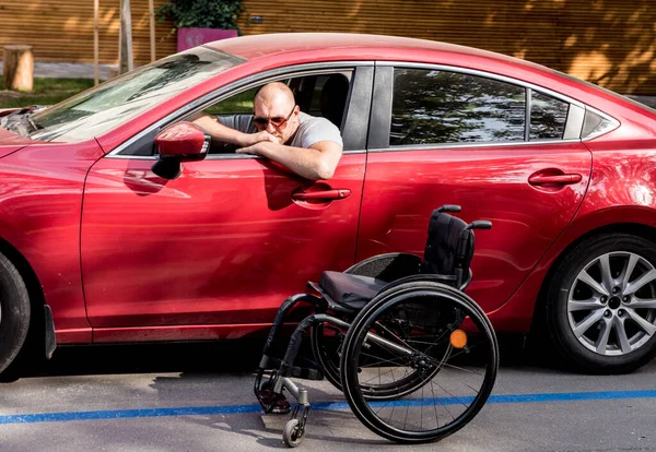 Young handicapped man on drivers seat of his car