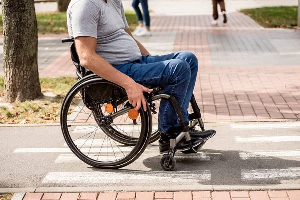 Gehbehinderter Mann im Rollstuhl an der Parkallee — Stockfoto