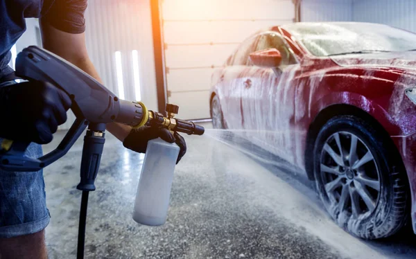 Trabajador de lavado de coches con espuma activa en un lavado de coches. — Foto de Stock