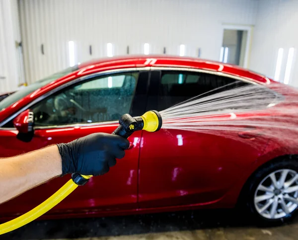 Travailleur de service laver la voiture sur un lavage de voiture. — Photo