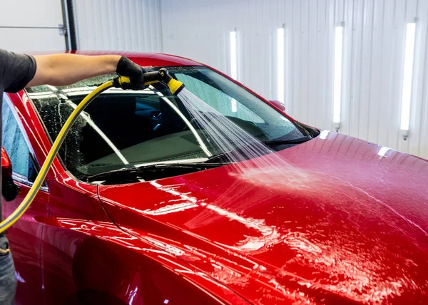 Service worker washing car on a car wash. — Stock Photo, Image