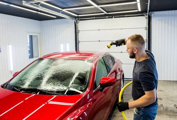 Servicearbetare som tvättar bil på en biltvätt. — Stockfoto