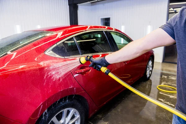 Travailleur de service laver la voiture sur un lavage de voiture. — Photo