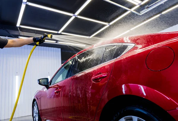 Travailleur de service laver la voiture sur un lavage de voiture. — Photo