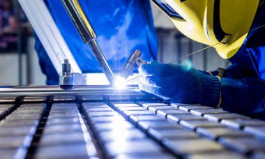 Argon kaynaklı çelik fabrikasında çalışan kaynakçı.