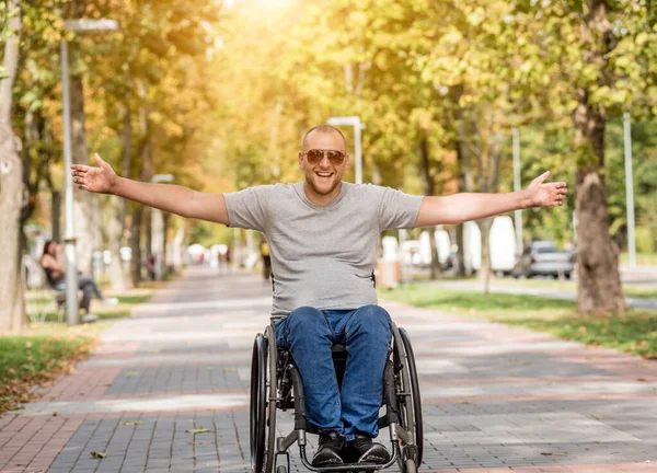 Gehandicapte man in rolstoel loopt in de steeg van het park — Stockfoto