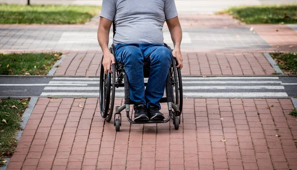 Hombre discapacitado en silla de ruedas preparándose para cruzar la calle en el cruce peatonal —  Fotos de Stock