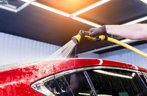 Service worker washing car on a car wash. — Stock Photo, Image