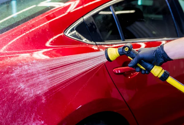 Travailleur de service laver la voiture sur un lavage de voiture. — Photo