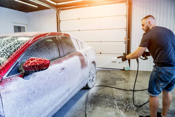 Trabajador de lavado de coches con espuma activa en un lavado de coches. — Foto de Stock