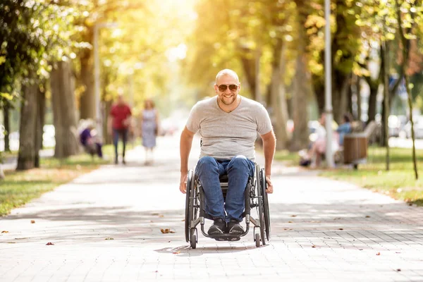 Gehandicapte man in rolstoel loopt in de steeg van het park — Stockfoto