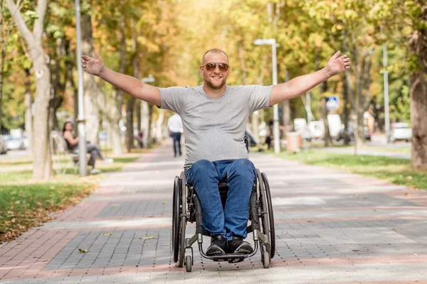 Handicapped man in wheelchair walk at the park alley