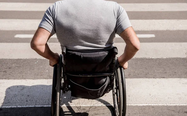 Homem deficiente em cadeira de rodas atravessando estrada de rua — Fotografia de Stock